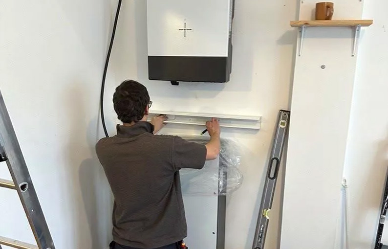 Man installing home battery.