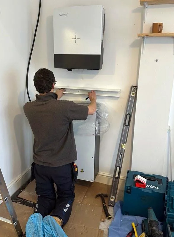 Man installing battery storage equipment.